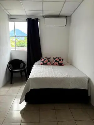 a bedroom with a bed in a room with a window at Hostal Proceres in San Salvador