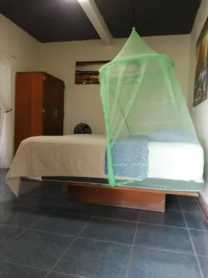 a bed with a net on top of it at Cabañas y café Kauani