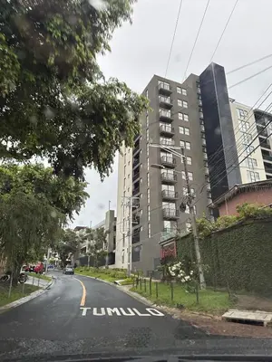 an empty street in front of a tall building at NU Lomas Garden in Antiguo Cuscatlán