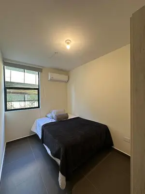 a small bedroom with a bed and a window at NU Lomas Garden in Antiguo Cuscatlán