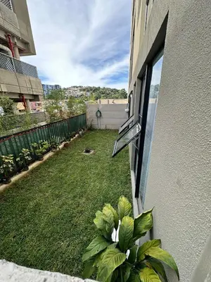 a view of a yard from a window of a building at NU Lomas Garden in Antiguo Cuscatlán