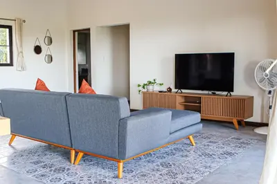 a living room with a blue couch and a tv at Finca La Guayaba, Nature and rural life