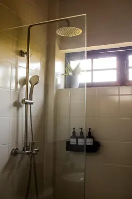 a shower with a glass door in a bathroom at Finca La Guayaba, Nature and rural life