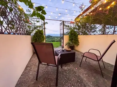 a patio with two chairs and a table with a view at Finca La Guayaba, Nature and rural life