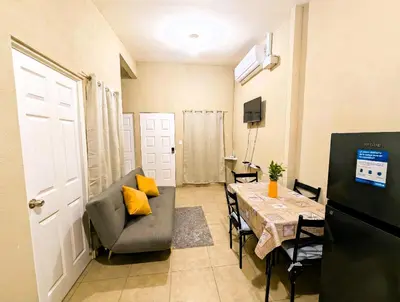 a living room with a table and a couch and a dining room at Via Trip House - Sonsonate in Sonsonate