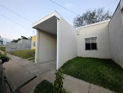 a white house with a garage at Via Trip House - Sonsonate in Sonsonate