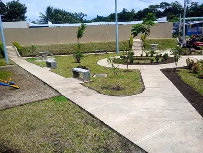 a park with benches and trees on a sidewalk at Via Trip House - Sonsonate in Sonsonate