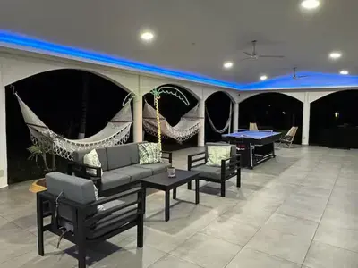 a living room with a couch and a ping pong table at Game Room • Fire Pit • Pool • Resort Access in Los Cóbanos