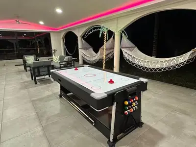 a ping pong table in the middle of a room at Game Room • Fire Pit • Pool • Resort Access in Los Cóbanos