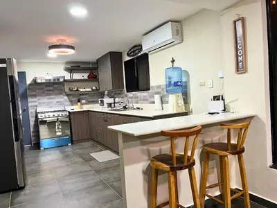 a kitchen with two bar stools at a counter at Game Room • Fire Pit • Pool • Resort Access in Los Cóbanos