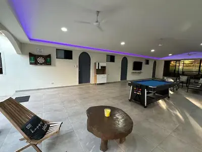 a living room with a ping pong table and a ping pong ball at Game Room • Fire Pit • Pool • Resort Access in Los Cóbanos