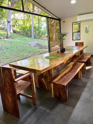 a large wooden table with benches and a window at Pool • Fire Pit • Game Room • Resort Access in Los Cóbanos