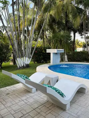 a couple of white benches next to a swimming pool at Pool • Fire Pit • Game Room • Resort Access in Los Cóbanos