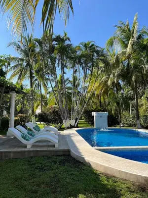 a group of chairs sitting next to a swimming pool at Pool • Resort Access • Game Room • Fire Pit in Los Cóbanos