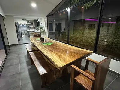 a large wooden table in a room with a large window at Pool • Resort Access • Game Room • Fire Pit in Los Cóbanos