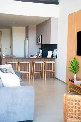 a living room with a couch and a kitchen at San Blas Loft in Playa San Blas