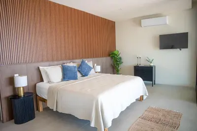 a bedroom with a large bed with blue pillows at San Blas Loft in Playa San Blas