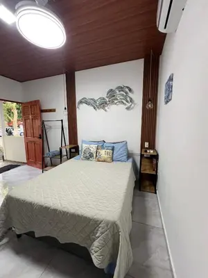 a bedroom with a bed with blue pillows on it at Sunzal Tropical 9 in Tamanique