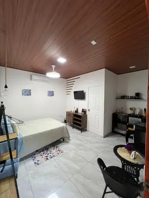 a bedroom with a bed and a table and a tv at Sunzal Tropical 9 in Tamanique