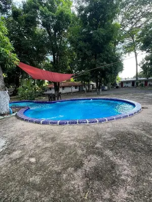 a red hammock is hanging over a small pool at Sunzal Tropical 9 in Tamanique
