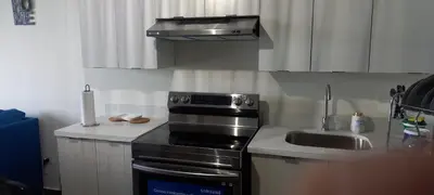 a kitchen with a stove top oven next to a sink at Apto 52 Lomas in Antiguo Cuscatlán