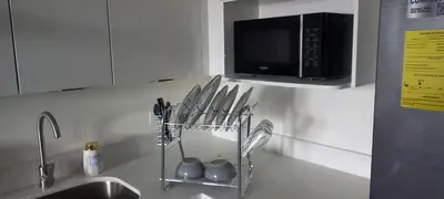 a kitchen counter with a microwave and some utensils at Apto 52 Lomas in Antiguo Cuscatlán