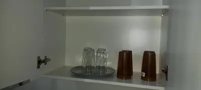 a shelf with three glasses and bottles on it at Apto 52 Lomas in Antiguo Cuscatlán