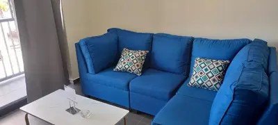 a blue couch with two pillows in a living room at Apto 52 Lomas in Antiguo Cuscatlán