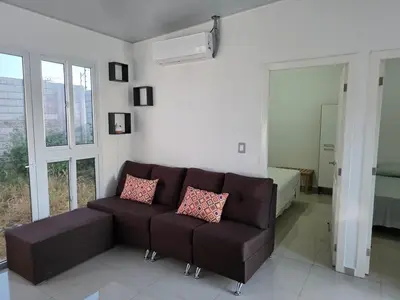 a living room with a brown couch and a bedroom at Casa Nueva San Miguel in San Miguel
