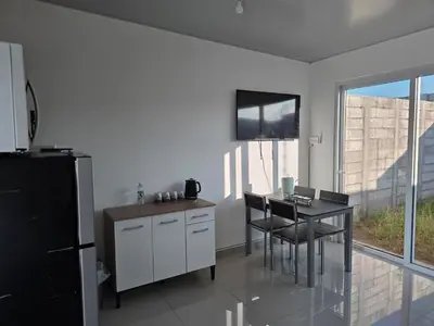 a kitchen with a table and a television on the wall at Casa Nueva San Miguel in San Miguel