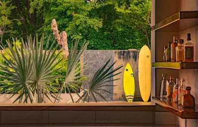 two surfboards are sitting on a counter with bottles at Casa Las Flores in El Cuco