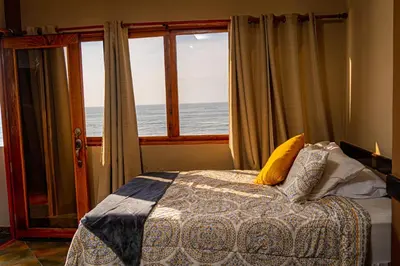 a bedroom with a bed in front of a window at AST Surf Hotel in La Libertad