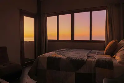 a bedroom with a bed and a large window at AST Surf Hotel in La Libertad