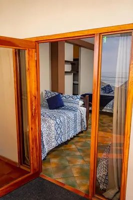 a room with a bedroom with a bed and a mirror at AST Surf Hotel in La Libertad