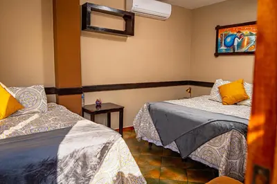 a room with two beds and a painting on the wall at AST Surf Hotel in La Libertad