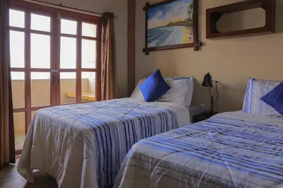 a bedroom with two beds and a sliding glass door at AST Surf Hotel in La Libertad