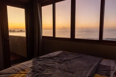 a bedroom with a window with a view of the beach at AST Surf Hotel in La Libertad