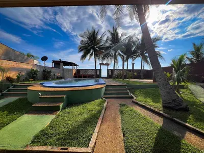 a swimming pool in a yard with palm trees at Quinta Hojas de Mar - Frente al Mar en Playa Las Hojas in El Rosario