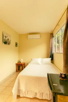 a bedroom with a white bed and a window at Hotel Castillo Blanco in El Zonte