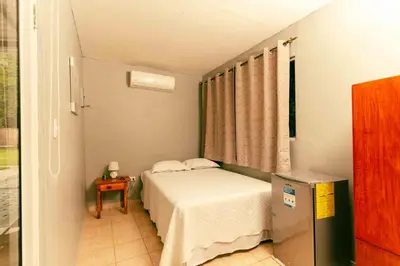 a small bedroom with a bed and a table at Hotel Castillo Blanco in El Zonte