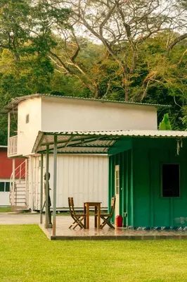 a green and white building with a table in front of it at Hotel Castillo Blanco in El Zonte