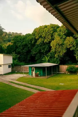 a green building with a table in a yard at Hotel Castillo Blanco in El Zonte