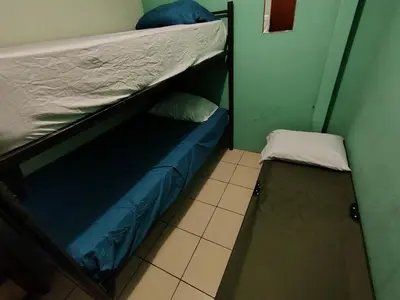 a bedroom with a bunk bed and a small bench at Rooms libertad in San Salvador