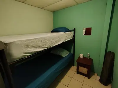 a bunk bed in a small room with a side table at Rooms libertad in San Salvador