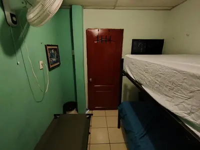 a bedroom with a bed and a red door at Rooms libertad in San Salvador