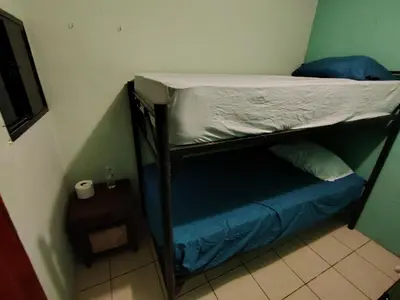 a bunk bed in a small room with a roll of toilet paper at Rooms libertad in San Salvador