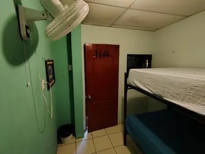 a room with a bed and a red door at Rooms libertad in San Salvador