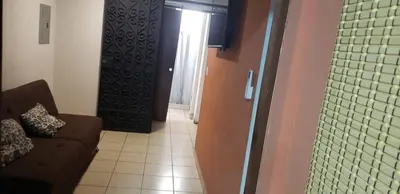 a living room with a brown couch and a door at Casablanca in San Salvador