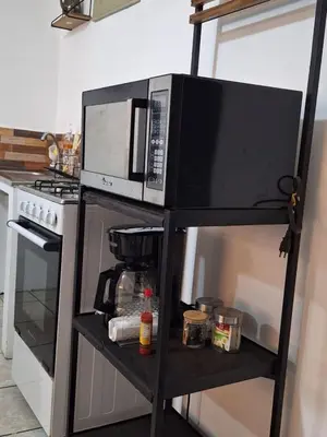 a microwave on a stand in a kitchen at Apartamento Rústico in Concepción de Ataco