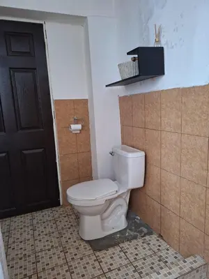 a bathroom with a toilet and a black door at Apartamento Rústico in Concepción de Ataco